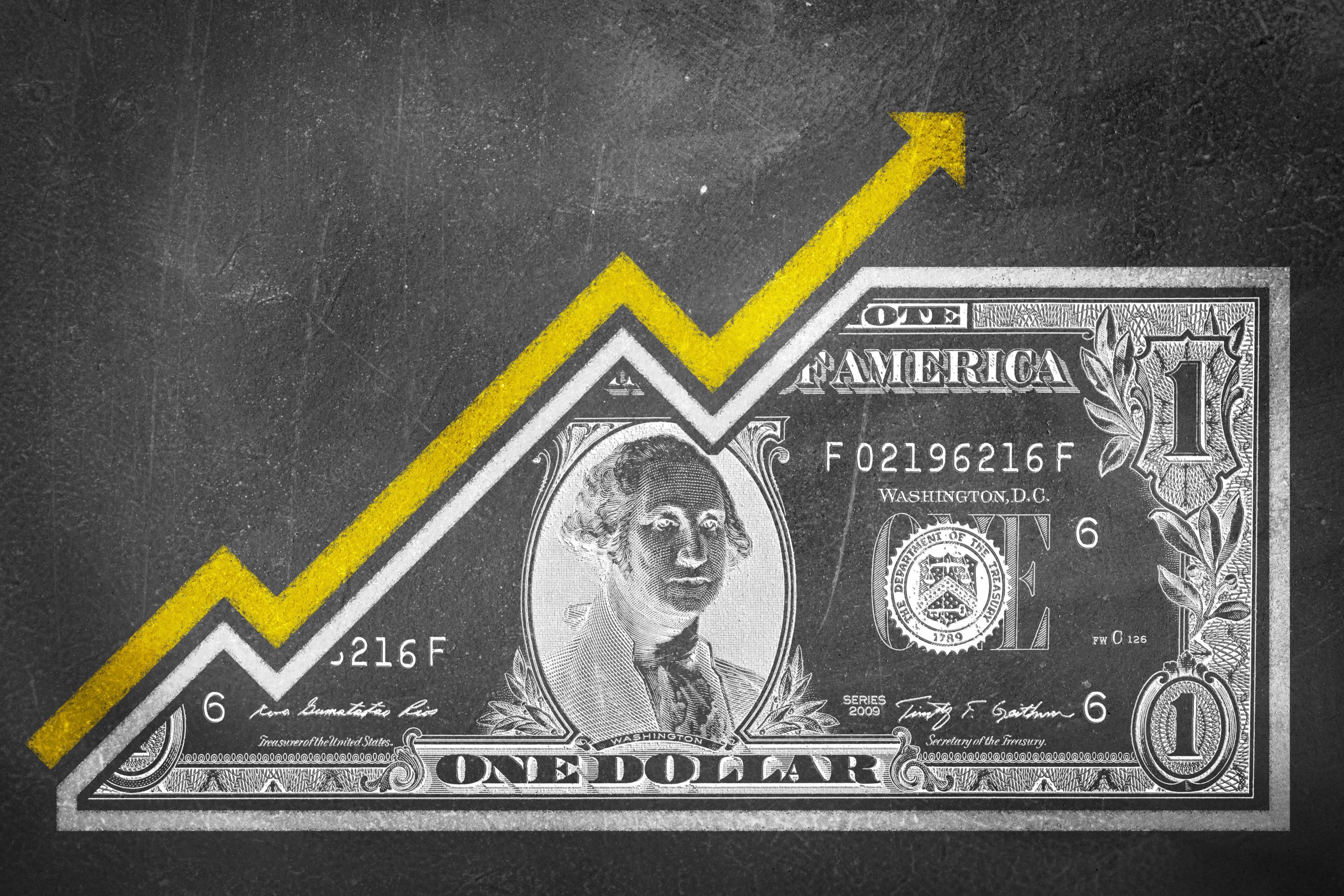 A money bill fused with an arrow drawn on a chalk board that together look like a growth graph and symbolize economic relationships.